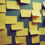 empty yellow post its on a dark wall